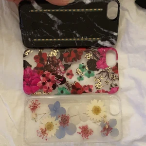Iphone 6 skal - Säljer tre skal till en Iphone 6. Ett mörkare med blommor, de ljusare med blommor är riktiga blommor i och ett skal med lampor både fram och bak. Köparen står för frakten.