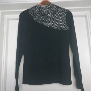 Tröja med metalldetaljer - Cool tröja med metallringar runt kragen och ner över bröstet📎