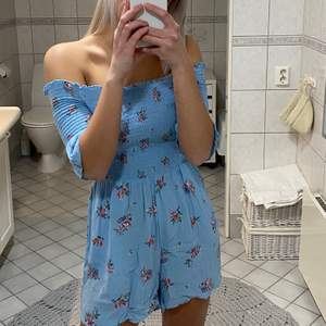 Supersöt blå-blommig playsuit. Köparen står för frakten