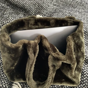 Samsoe väska - Helt ny (prislapp kvar) väska från samsoe, den är mörkgrön i fuskpäls. Jättefin och går att reglera i två olika storlekar. På första bilden har jag min MacBook i så den är perfekt till skolan:)⭐️ Hör av dig om du är intresserad!!