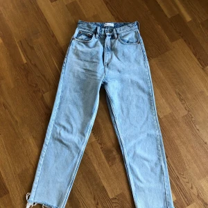 ZARA jeans strl 34 - Perfekta blå jeansen med slitningar nedtill. Strl 34 men skulle säga att de passar en mindre 36a