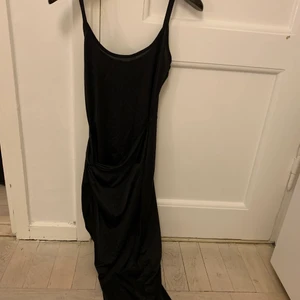 Klänning - Svart snygg tight klänning med slits. Halv glansig 