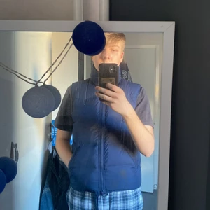 Boomerang dunväst - Blå dunväst ifrån Boomerang. Snygg, stilig och varm. Perfekt för kyliga vår och höst dagar eller som extra lager under ett tunnare vinterplagg. Storlek L, skulle gissa på att det är en kvinno L så den passar som en Herr M. Mörkblå med röd insida.