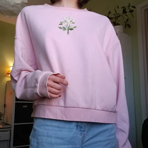 Ljusrosa tröja med broderi - Har en liten missfärgning som syns några cm över mitt pekfinger på första bilden. Är storlek L men funkar på mig som är S/M. Köpt seconhand så ver inte märket, broderiet är av mig.
