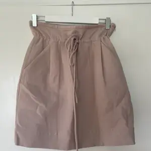 Mini kjol från Iro i gammel rosa med knytning fram.