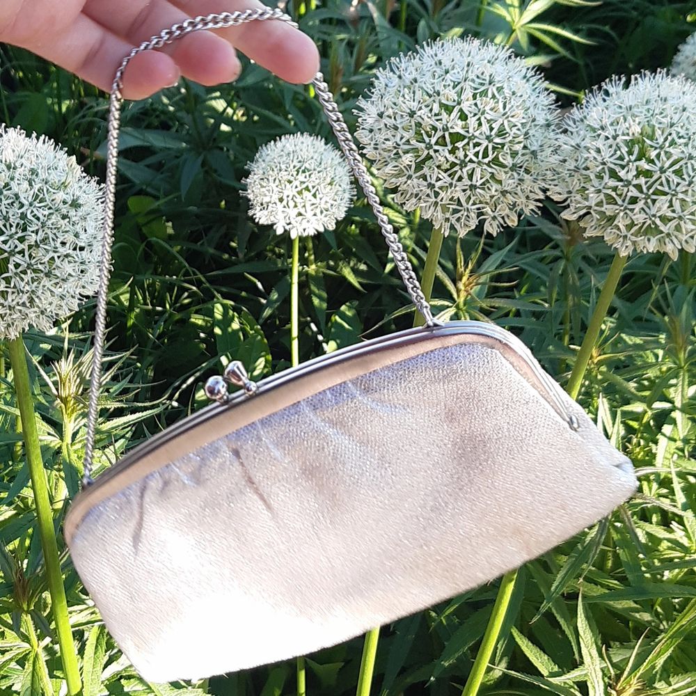  The bag was bought recently and never used,, it is in excellent condition. It has an opening in the middle and has a white silver glittery fabric on the outside and comes with a nice narrow silver bag strap (budgivning i kommentarsfältet). Väskor.