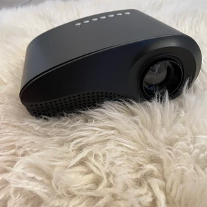 Mini projektor svart - Oanvänd svart mini projektor, nytt skick. Perfekt för att kolla film och annat. Kontroll, sladdar ingår, men HMDI kabel ingår ej. Priset kan diskuteras vid snabb affär