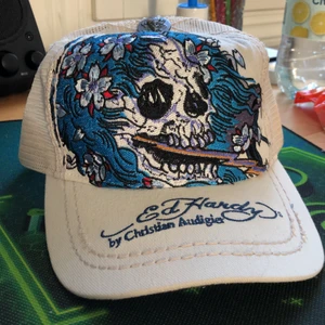 Ed hardy keps - Äkta ed hardy keps som har varit använd fåtal gånger ha dock en defekt bak där man justerar storlek som ni ser på bild 2