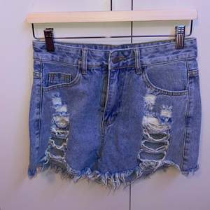 Blue jeans shorts with rips. Recently bought, never been worn.