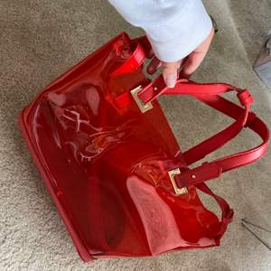 Hej säljer denna snygga röda väska som är genomskinlig I plastmaterial