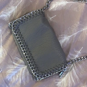 Väska - Jätte snygg väska från TIAMO i storlek small. Jättebra skick! På sista bilden kan ni se skillnaden mellan en tiamo väska i strlk medium och i strlk small! Men säljer alltså den lilla gråa! Köparen står för frakten!🖤 Kan säljas billigare vid snabb affär!!