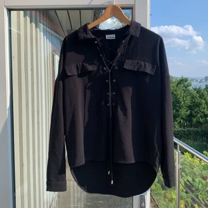 Blus/skjorta - Svart blus/skjorta med knytning. Använd 2-3ggr, nyskick. Köparen står för frakt. 