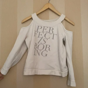 Vit långärmad - Vit långärmad tröja med silvrigt tryckt. På trycket står det ”perfekt is Boring”