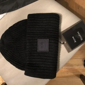 Acne mössa svart oanvänd  - Svart acne studios mössa pansy beanie smiley face. Nyskick oanvänd