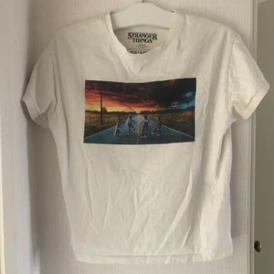 Stranger Things T-shirt - Helt oanvänd stranger things t-shirt från Pull & Bear! Superfint skick på den! Stort tryck på bröstet och även en litet tryck på ena armen! Jättemjukt och skönt material! Den är i storlek XS men väldigt oversize så kan nog passa både XS, S och M!🌻