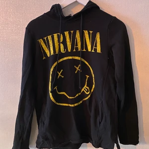Svart tröja med tryck nirvana H&M - Svart hoodie från h&m med gult tryck av nirvana. Endast använd ett fåtal gånger. Frakt betalar mottagaren för. Pris går att diskutera! Kan skicka fler bilder✨