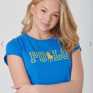 Blå polo sport  tröja med gul text. - En ljus  blå polo sport tröja,med gul text,en häst i mitten av texten.Bilden är lånad ifrån kidsbrandstore. Jag köpte den ifrån kidsbrandstore 2020 ungefär i maj så har ungefär haft den i ett år. Men den är jätte bra skick inga hål eller fläckar. Köparen står för 10kr frakt 🚚📦 så med frakten blir det 150. är inte 100% säker i storlek men jag tror den var i XS eller XXS men jag hade den när jag var 10 men tror även att den funkar för 8-11.Skriv till mig privat om frågor till storlek. 