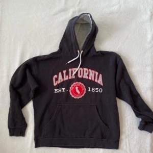 Svart California-hoodie med rött tryck.
