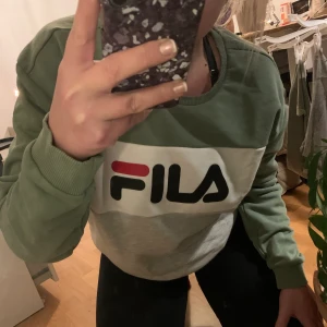 Grön & grå Fila - Lägger ut igen med bättre bilder! 😏 Köpt för att sitta oversized 🥰 Crewneck från Fila. Använd 1 gång, toppenskick alltså! färgen är mycket snyggare i verkligheten än på bilderna 😍💕 Nypris 579kr