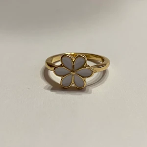 Ring - Vit silverring med gulddetaljer i form av en blomma.