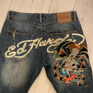 Ed Hardy jeans  - Sjuka Ed Hardy jeans med tryck på röven. Köpta secondhand så det finns lite svarta märken på framsida knä som man kan se i sista bilden, men annars är dom i toppskick. Storlek 33/34 men skulle säga att midjan är lite mindre och längden passar mig som är 182 cm. Straight passform med low / mid waist. Sjukt svåra att få tag på, har inte sätt ett par likande 