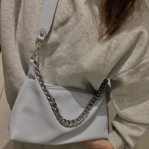 ASOS Väska - Ljusblå väska från ASOS med silvriga detaljer. Själva axelremsbandet är avtagbart och då kan väskan användas som en ”axelväska” med den silvriga kedjan (se bild 2). Den är rymlig och i perfekt size enligt mig men kommer tyvärr inte till användning därav att jag säljer 💙
