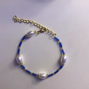 Ett superfint armband som passar till halsbandet som är den andra annonsen i profilen.                                 💙✨Armbandet har stora vita pärlor och blåa, guldiga glaspärlor. Armbandets längd kan du bestämma SJÄLV! FRAKT INGÅR i priset.