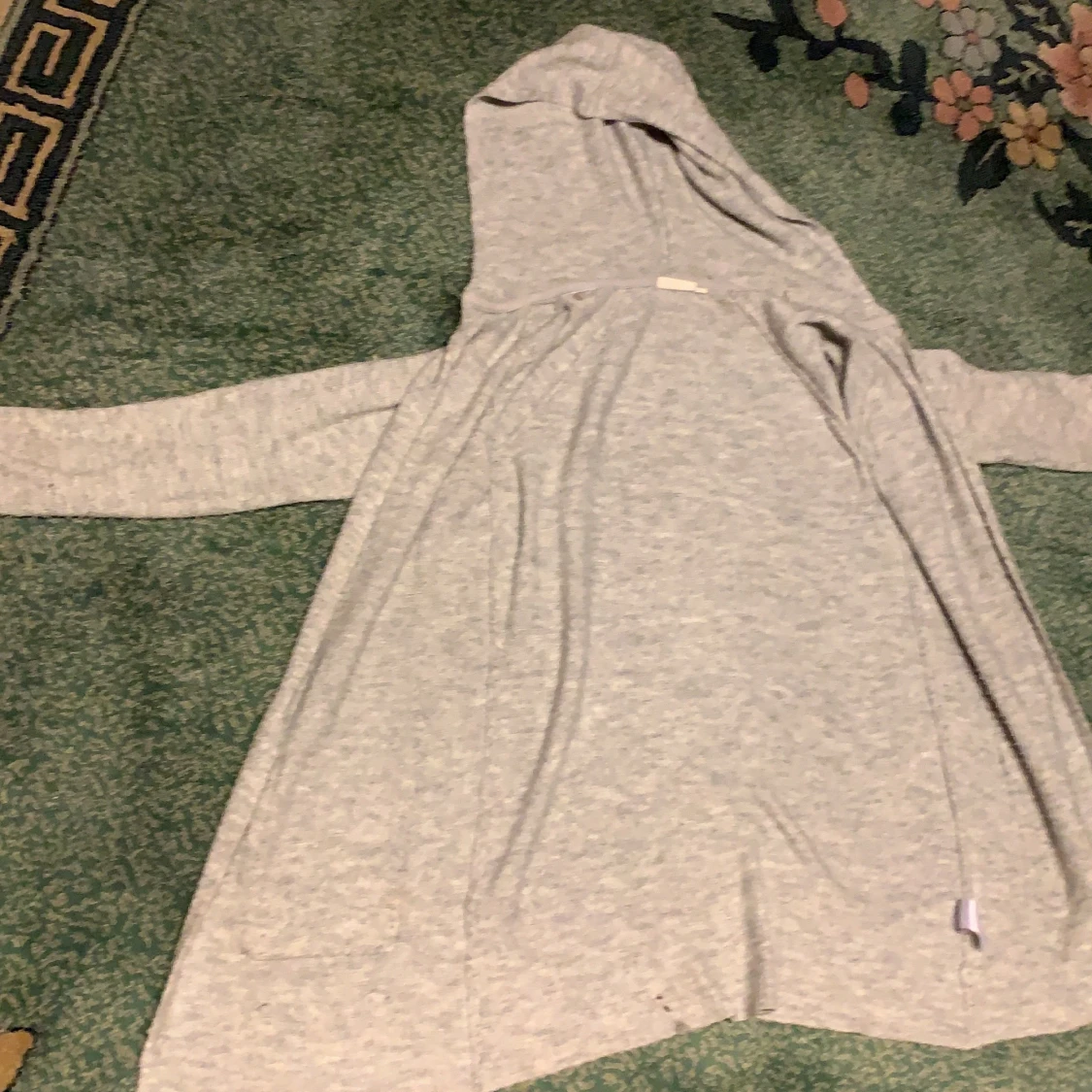 Grå lång kofta med luva. 