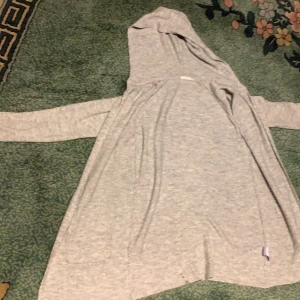 Grå lång kofta med luva.  - Grå kofta med luva lång. Har använt den några gånger men den är i bra skick:)