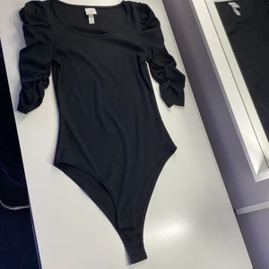 Svart Body med puffärm - Här har vi en svart body med puffärm från hm i storlek XS. Har bara använt några få gånger. Köparen står för frakten!🙂
