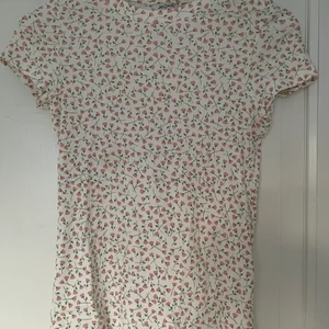 T-shirt  - Supersöt vit t-shirt med rosa blommor på. Knappt använd. 