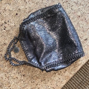 Stella McCartney Tiny Falabella  - Gullig Stella McCartney väska från FW15, modellen heter Tiny Falabella i färgen är Ruthenium. Inköpt på min gamla arbetsplats, Stella McCartney butiken i Stockholm som numera är stängd. Minns inte inköpspris men samma modell såldes på Vestiaire i november för 4300kr, också i sparsamt använt skick. Går bara att ladda upp tre bilder men skickar gärna fler vid intresse. Pris kan diskuteras! 
