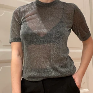 Glittrig svart topp från Moss Copenhagen - Svart glittrig topp, perfekt för nyår! Materialet är ganska genomskinligt som man kan se på bilderna. Endast använd ett fåtal gånger. Skickar gärna fler bilder. Kolla gärna in andra saker jag säljer så kan jag erbjuda paketpris. Vid köp över 300kr kan jag mötas upp i Stockholms innerstad!