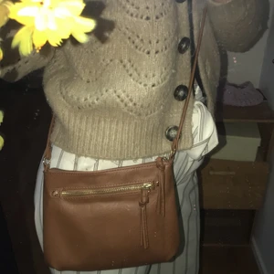 Snygg väska - Säljer denna sjukt snygga bruna väskan med guldiga detaljer som tyvärr inte kommer till användning. Pris kan diskuteras💕