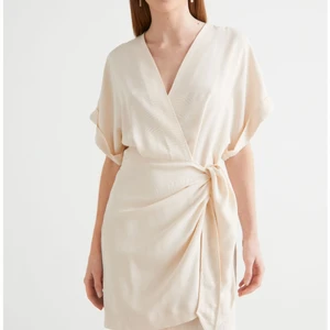 Omlottklänning & other stories  - Cremefärgad klänning från & other stories i str 38. Var för stor för mig som har 36, helt oanvänd,  endast provad. Sjukt snygg! Snart slutsåld i butik! Nypris 790:-