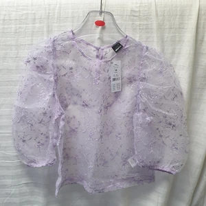 Lila mesh blus - Lila mesh blus köpt från Gina Tricot. 🙂 Har ett blommigt mönster som är broderat toppen. Fint med ett linne eller kort topp under. 💕 Puffig ärm som kommer ner till armbågarna. Ny, med lapp kvar! Nypris: 399kr