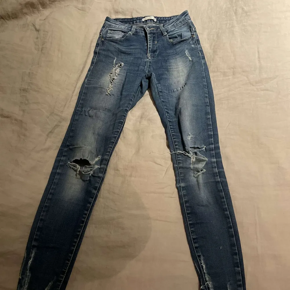 Ett par blåa jeans med hål i i storlek 34. Nypriset ligger på 200kr men säljer för 120kr dom har lite defekter på sig men inget man tänker på.. Jeans & Byxor.