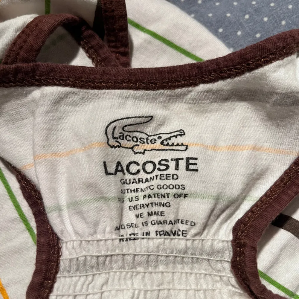 Gulligt Lacoste linne köpt på loppis. Står ingen storlek men skulle gissa S. Ganska använda. 🧡. Toppar.