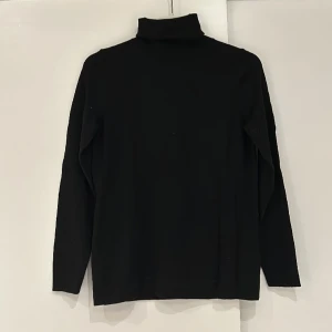 Gant Stickad Polo Tröja - Supersnygg finstickad svart polotröja från Gant i storlek XS. Materialet är 100% ull. Har inte använt tröjan många gånger så den är i mycket fint skick. FRAKT TILLKOMMER!  Skickar ENDAST med postens blåa påsar. 