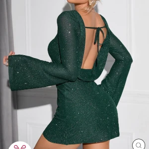 Klänning öppen rygg - Trendande klänning från Parthea! Öppen rygg, glittertyg (inga jobbiga paljetter/glitter som lossnar). Skön & mjuk! Har undertyg så syns inte igenom & inte för kort. Köpte fel strl o returen är dyrare än klänningen. Nypris 470 kr. Oanvänd förutom prov