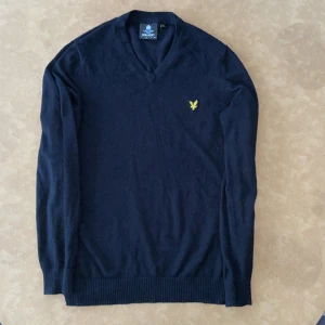 Stickad tröja - V ringad finstickad tröja från Lyle & Scott. Svart, mkt fint skick. 85% bomull 15%ull. Storlek M