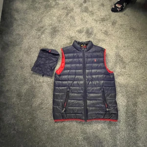 Ralph lauren väst - Ralph lauren väst som knappt är använd och i väldigt bra skick. Inga defekter eller något  Det medföljer en liten Ralph lauren påse som man kan lägga västen i.  Retail:2000 Cond:9/10 Mitt pris:800 Perfekt nu till våren!!.