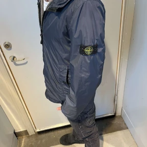 Stone Island Jacka - Vindjacka 8/10 skick, inte min jacka (säljs åt en vän). S/170cm/14y. Liten defekt under luvan, kom privat för fler frågor eller bilder😄