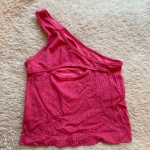 Rosa one shoulder festtop - Asymmetrisk off shoulder topp med en snygg cutout ovanför bysten. Perfekt till fest eller för att krydda till vardagen!💗