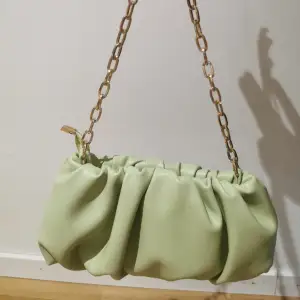En stilig grön väska med fake guld kedja. 