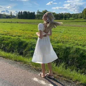 Vit lång klänning med puffärm  och snörning i ryggen  - Säljer denna vita klänning med snörning i ryggen och puffärm. Endast använd vid 1 tillfälle så bra skick. Strl xs och säljer för 150kr