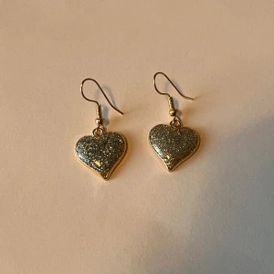 Hjärtörhängen  - Blågrå, glittriga hjärtörhängen. Helt nya och oanvända. 