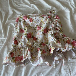 Kjol - Den är kort och har en fin detalj på sidan. Den är blommig och somrig.❤️
