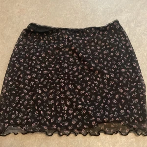 Blomstrig kjol - storlek xxs, ca 29cm lång och ca 38cm bred runt benen. Andvänd en gång. Väldigt bra skick. 