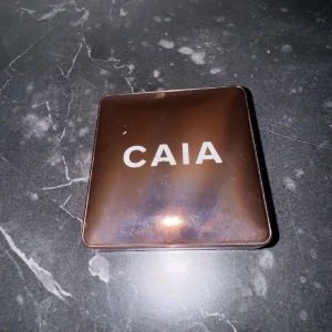 CAIA Bronzer Gold Coast - CAIA bronzer med spegel i färgen gold coast. Använd några gånger men inte många, Max 3-4. Mycket kvar. Väldigt bra och prisvärd✨säljer pga slutat med smink. Nypris: 395kr.  Frakt 18kr som billigast annars som ni vill💖💞